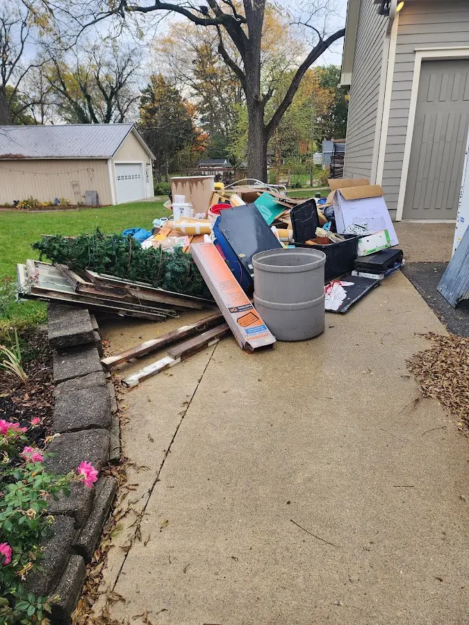 Dumpster being loaded with debris for 12 Yard Dumpster Rental in Pine Hills